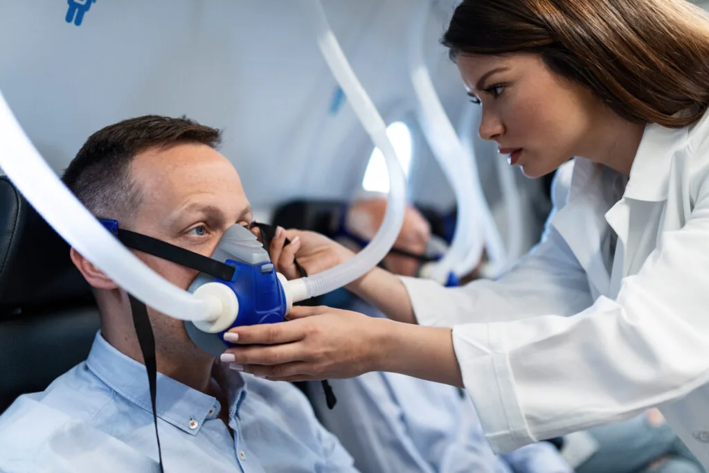 Healthcare professional assisting patient with respiratory therapy